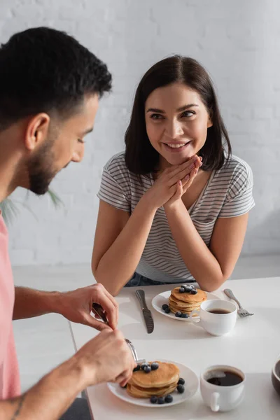 Sonriente Joven Con Las Manos Cerca Cara Mirando Novio Comiendo — Foto de Stock