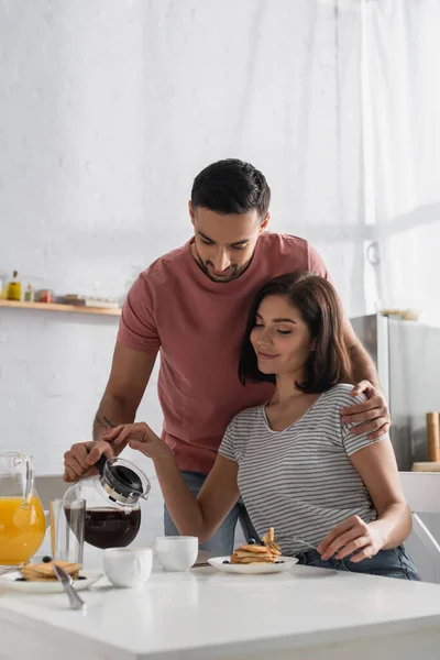 Felice Giovane Uomo Abbracciando Fidanzata Versando Caffè Dalla Pentola Alla — Foto Stock