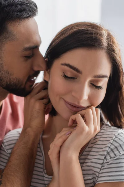 若い男キス笑顔の女性と目を閉じて手を近くの家で — ストック写真