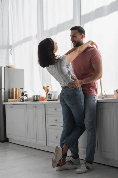 Positive Young Woman Hugging Boyfriend Hands Shoulders Kitchen — Stock Photo, Image