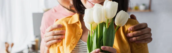 Visão Parcial Jovem Abraçando Namorada Com Buquê Flores Cozinha Banner — Fotografia de Stock
