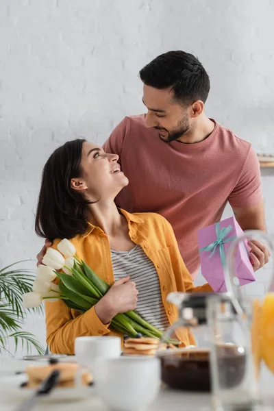 Joven Positivo Que Presenta Caja Regalo Novia Con Ramo Flores — Foto de Stock