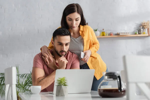 Serious Young Woman Holding Cellphone Touching Hands Boyfriend Working Laptop — 스톡 사진