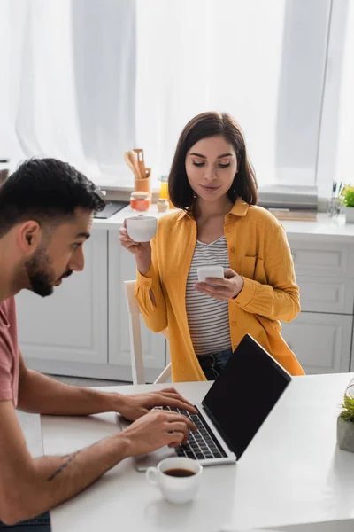 Tersenyum Wanita Muda Minum Kopi Dan Pesan Ponsel Dekat Pacar — Stok Foto