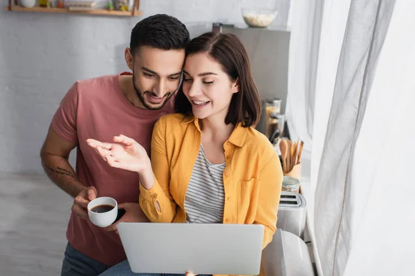 Smiling Young Woman Sitting Laptop Outstretched Hand Boyfriend Coffee Cup — 스톡 사진