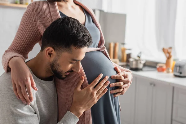 Young Man Closed Eyes Gently Hugging Belly Pregnant Woman Kitchen — Stock Photo, Image