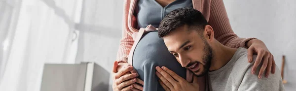 Jovem Gentilmente Abraçando Barriga Mulher Grávida Cozinha Banner — Fotografia de Stock