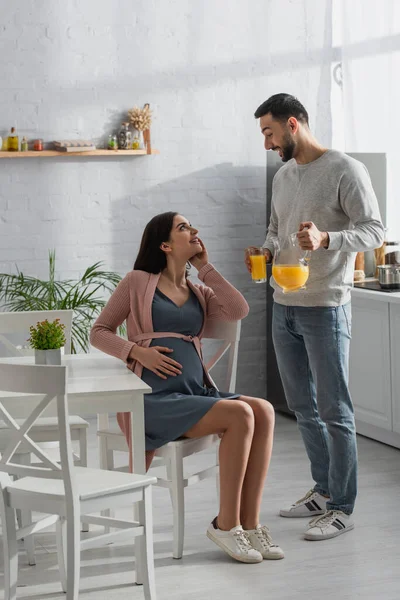 Sonriente Joven Pie Con Frasco Vaso Jugo Naranja Cerca Mujer — Foto de Stock