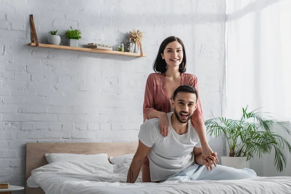 Glückliches Junges Paar Sitzt Mit Weißer Bettwäsche Auf Dem Bett — Stockfoto