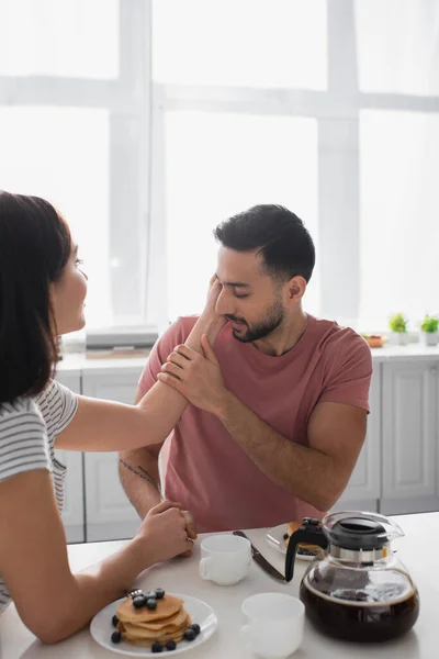 Jovem Gentilmente Segurando Beijando Mão Namorada Sentada Mesa Cozinha — Fotografia de Stock