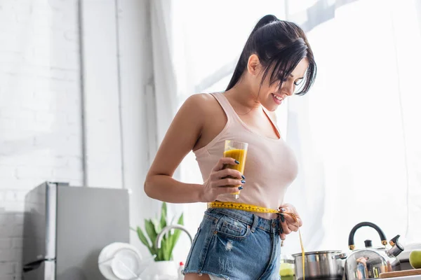 Feliz Joven Mujer Sosteniendo Vaso Batido Mientras Mide Cintura — Foto de Stock