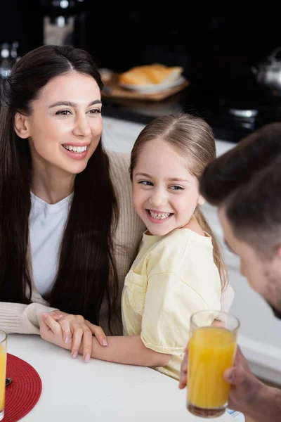 Cheerful Mother Daughter Holding Hands Blurred Dad Holding Orange Juice — Stock Photo, Image