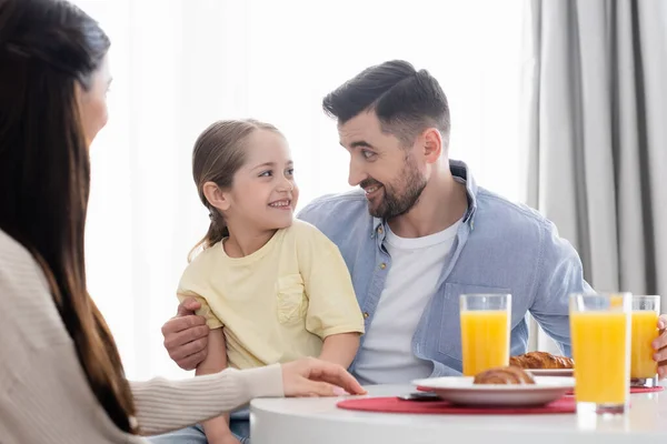 Sonriente Chica Mirando Papá Cerca Borrosa Madre Durante Desayuno — Foto de Stock