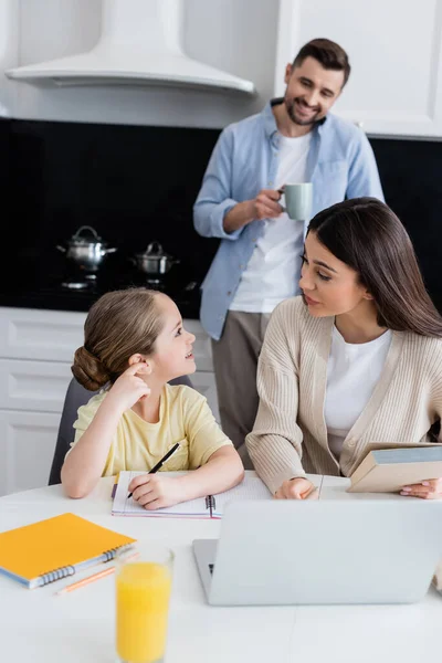 Mamma Figlia Che Guardano Mentre Fanno Compiti Vicino Papà Sorridendo — Foto Stock