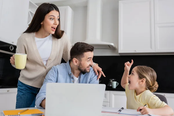 Upphetsad Flicka Visar Idé Gest Nära Förbluffad Pappa Och Mamma — Stockfoto