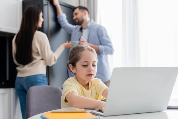 Blurred Couple Talking Child Typing Laptop While Doing Homework — Stock Photo, Image