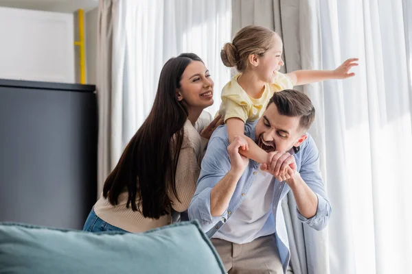 Leende Kvinna Nära Lekfull Man Bita Hand Dotter Samtidigt Kul — Stockfoto