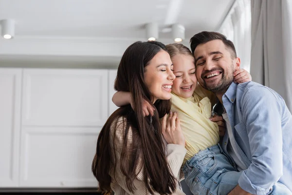 Happy Parents Daughter Closed Eyes Embracing Home — Stock Photo, Image