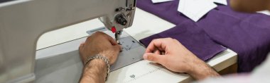 Moda atelie 'sinde dikiş makinesi kullanan terzinin kısmi görünümü, afiş
