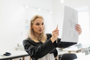young fashion designer measuring proportions of drawing with pencil clipart