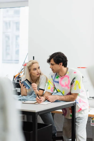 Young Designer Holding Color Palette While Talking Colleague Tailor Shop — Stock Photo, Image