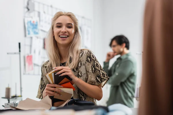 Gelukkig Ontwerper Met Kleurenpalet Glimlachen Camera Terwijl Collega Denken Wazig — Stockfoto