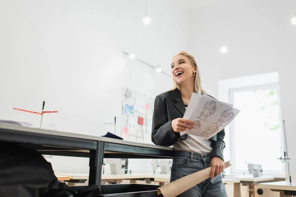 Pen Motedesigner Med Tegninger Symønster Som Ler Mens Han Ser – stockfoto