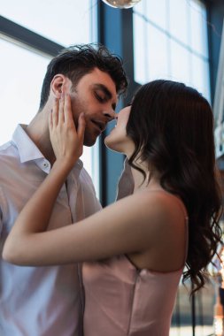 Mutlu kadın nazikçe erkek arkadaşının yüzüne dokunuyor. 