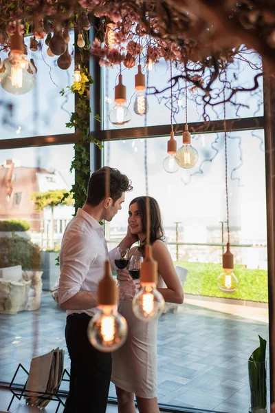 Elegante Pareja Sosteniendo Copas Vino Tinto Mirándose Restaurante — Foto de Stock