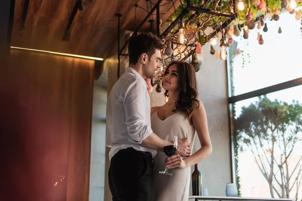 Cheerful Man Hugging Joyful Girlfriend Slip Dress Restaurant — Stockfoto