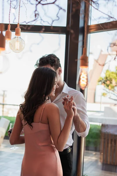 Mann Und Fröhliche Frau Halten Händchen Restaurant Neben Glühbirnen — Stockfoto