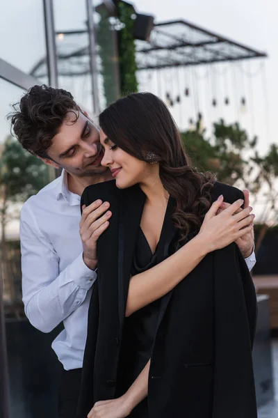 Homem Elegante Abraçando Mulher Alegre Blazer Preto — Fotografia de Stock