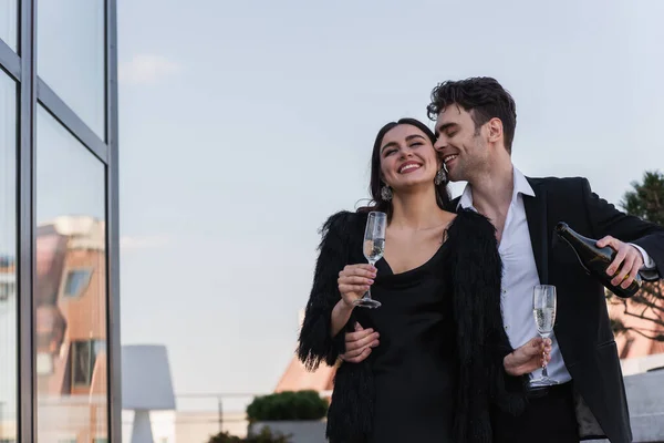 Happy Man Holding Bottle Champagne Cheerful Girlfriend Faux Fur Jacket — Stock Photo, Image