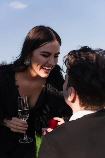 Man Maakt Aanzoek Aan Gelukkige Vrouw Met Glas Champagne — Stockfoto