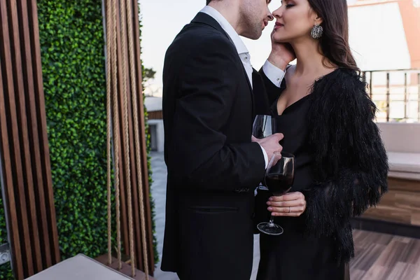 男は女にキスしてテラスで赤ワインを飲みながら — ストック写真