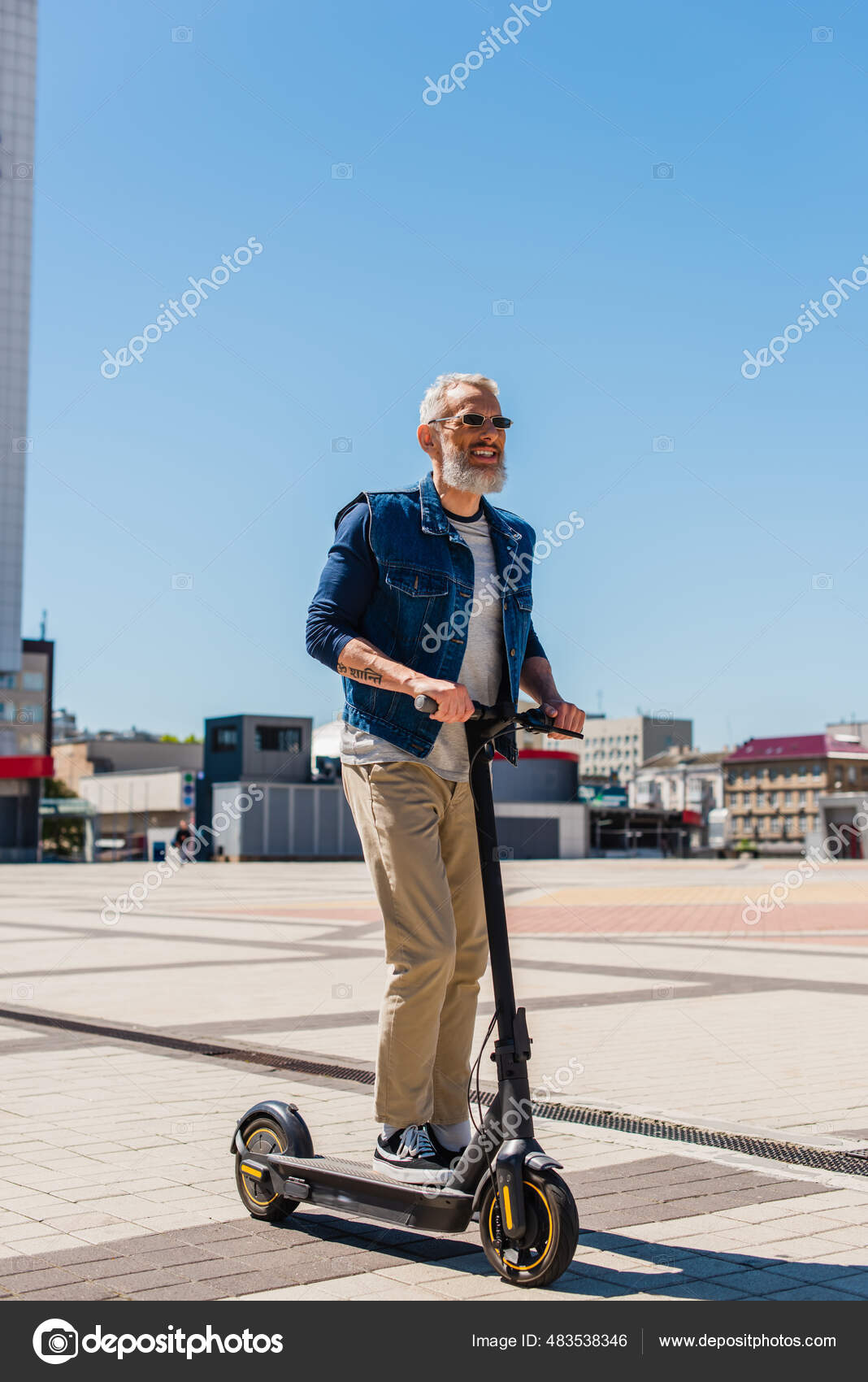 Man in a business suit and sunglasses rides an electric scooter on one and  laughs Stock Photo by StudioPeace