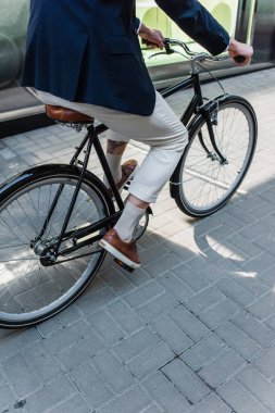 partial view of man riding bicycle outside