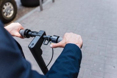high angle view of mature businessman riding electric scooter 
