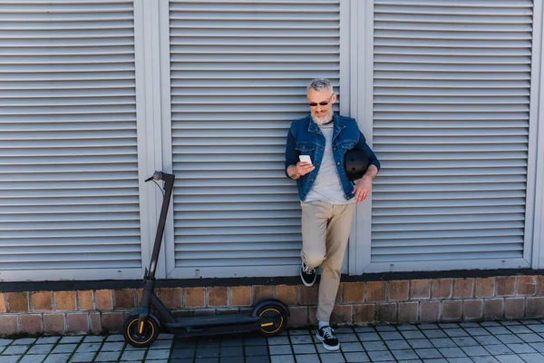 Full Length Happy Mature Man Sunglasses Using Smartphone Scooter — Stockfoto