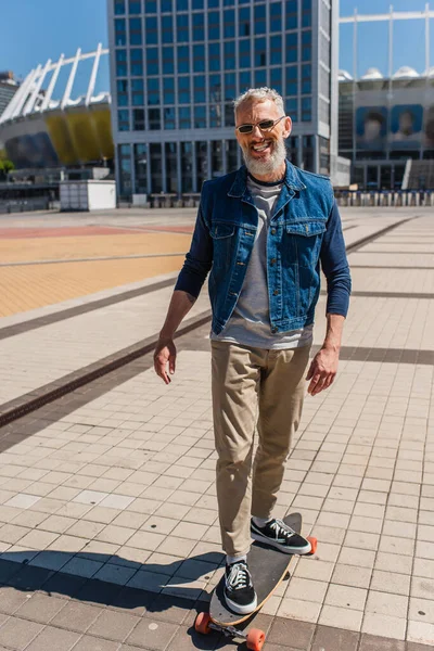 Positive Middle Aged Man Sunglasses Riding Longboard Urban Street — Foto de Stock