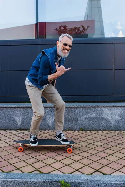 Full Length Happy Man Open Mouth Riding Longboard Showing Rock — Stock Photo, Image