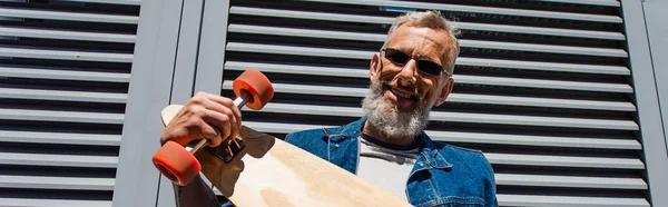 Pleased Middle Aged Man Sunglasses Holding Longboard Banner — Stok fotoğraf