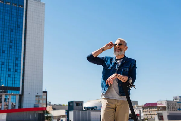 Fröhlicher Mann Passt Sonnenbrille Neben Scooter Stadtstraße Auf — Stockfoto