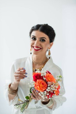 Neşeli Hintli gelin mehndi 'nin elinde bir buket çiçekle beyaz