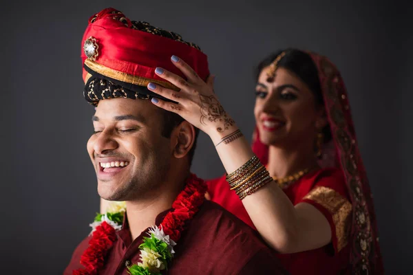 Vrolijk Indiaans Bruid Dragen Tulband Hoofd Van Bruidegom Geïsoleerd Grijs — Stockfoto