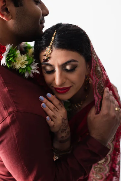 新郎ホワイトで隔離されたスカーフで幸せなインドの花嫁を抱擁 — ストック写真