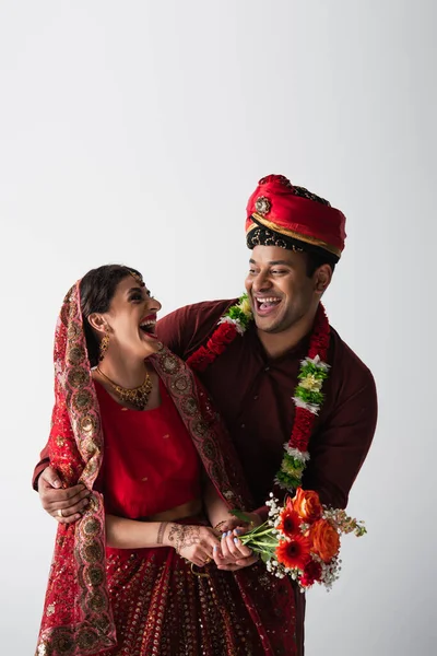 Noivo Indiano Feliz Turbante Abraçando Noiva Alegre Sari Com Flores — Fotografia de Stock