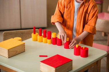 Montessori okulunda kırmızı ve sarı blokları birleştiren çocuk manzarası