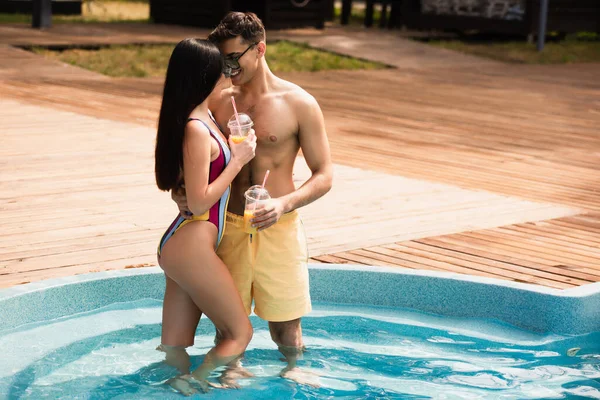 Hombre Traje Baño Abrazando Novia Con Bebida Piscina — Foto de Stock