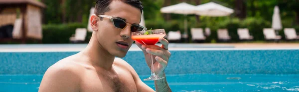 週末にプールでカクテルを持ってる若い男バナー — ストック写真